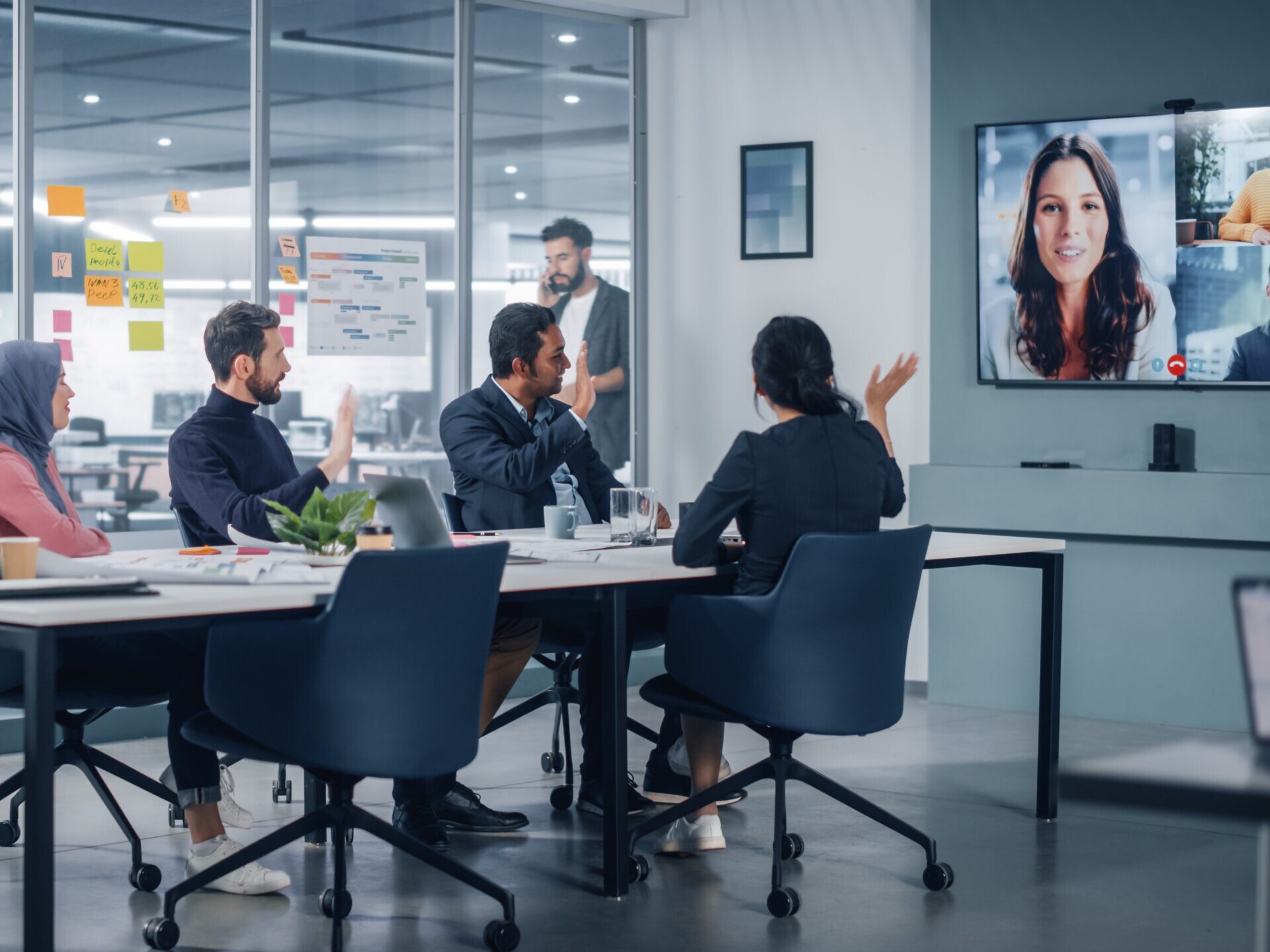 workers in a conference room on a video call